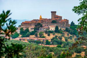 Castello medievale circondato da colline verdi e alberi rigogliosi.