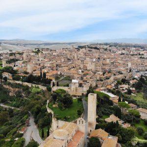 Vista aerea di una città medievale con torri e mura antiche.